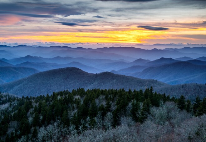 A colorful sunset over the Blue Ridge Mountains shrouded in a wintery haze.