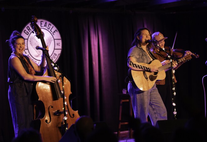 Three performers playing upright bass, fiddle, guitar and singing at The Grey Eagle in Asheville.
