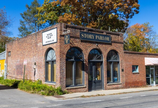 The exterior Story Parlor—a brick building with tall arched glass windows.